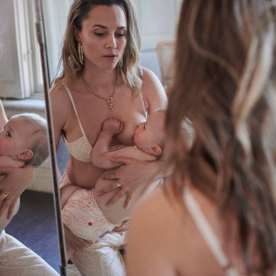 Nina Pierson feeding baby in MAMA'EN collection smiley diaper
